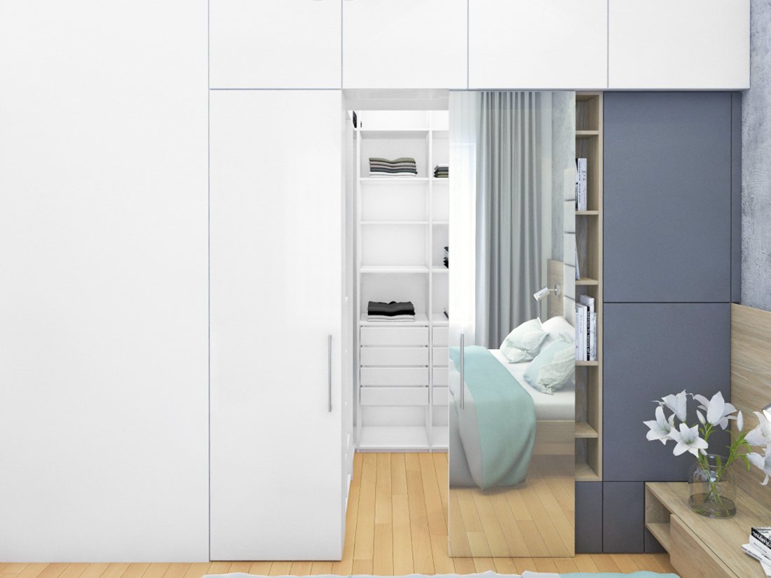 Úložné priestory spálne vo farbách biela a šedá so šatníkom za posuvnými dverami so zrkadlom