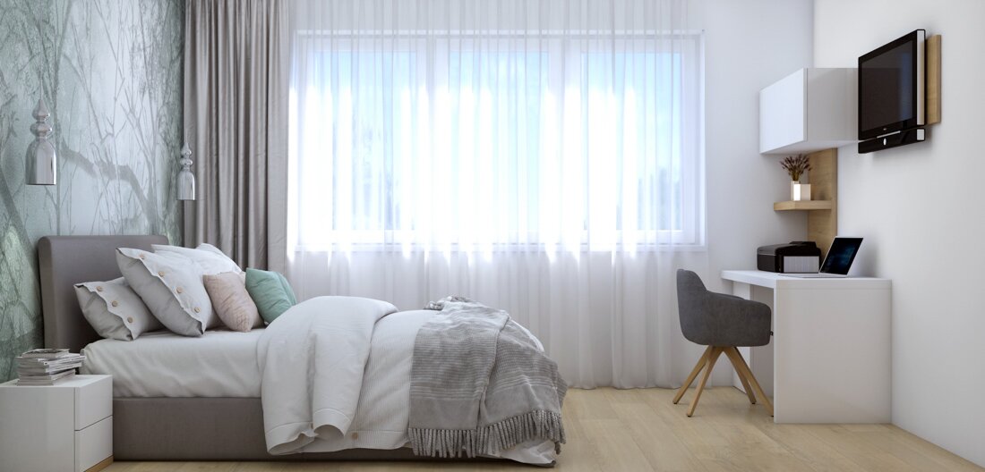 Spálňa s pracovným kútom a posteľou s nočnými stolíkmi vo farbách bielej, šedej a dreva s výnimkou mentolovej tapety